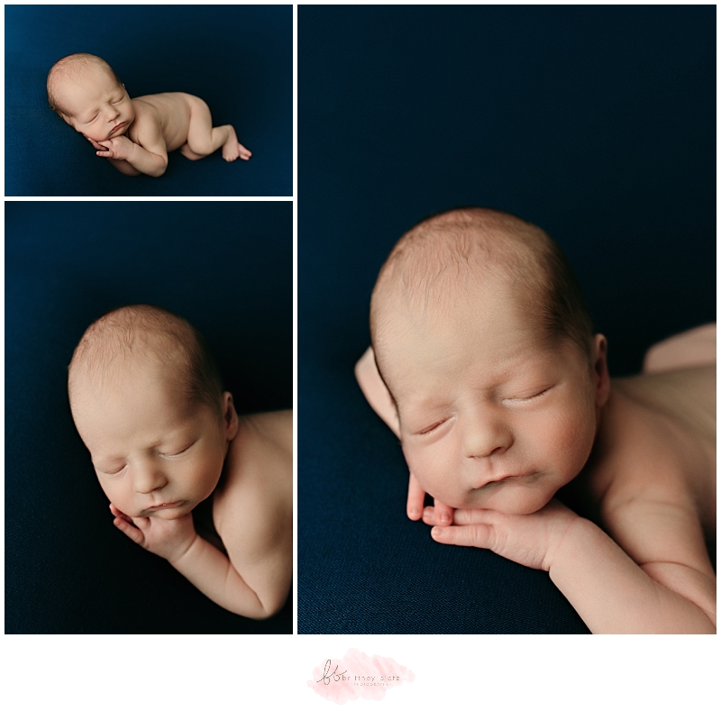 Newborn baby boy sleeping on navy blue fabric