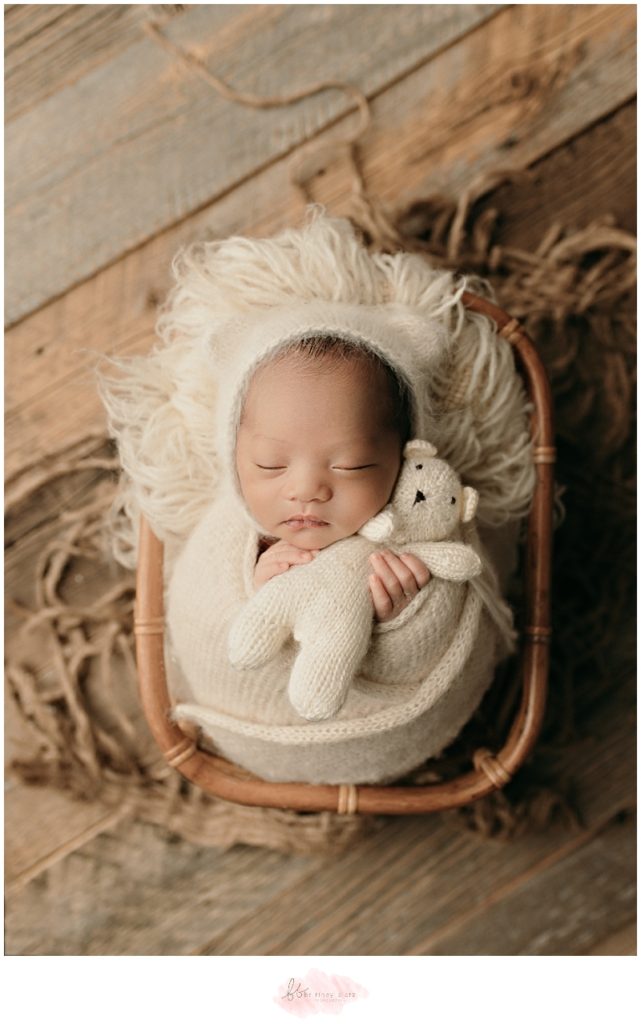 Baby boy holding tiny bear stuffed animal