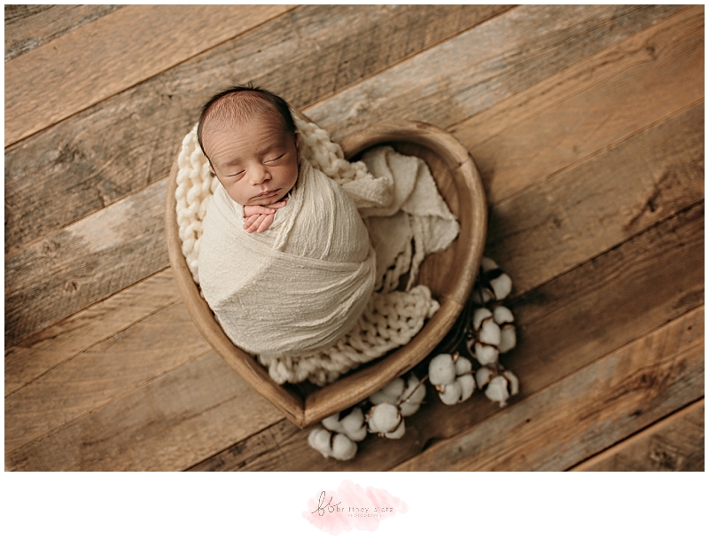 Baby boy wrapped up in heart bowl with cotton