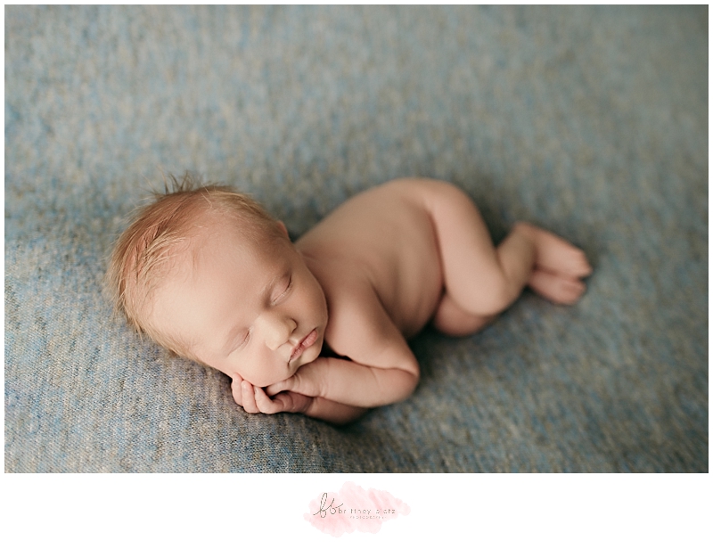 newborn baby boy sleeping on side on blue blanket