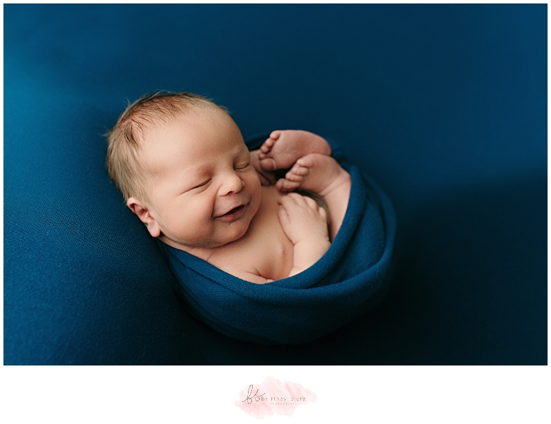 Smiling sleeping newborn baby boy in Calgary