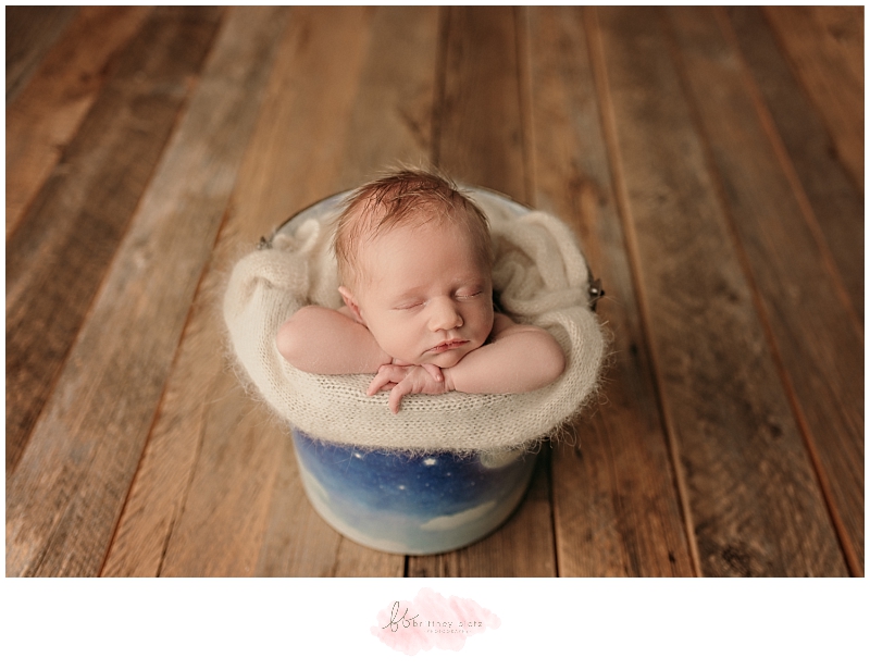 Newborn baby boy sleeping in bucket