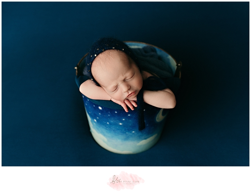 Baby boy in a bucket with blue bonnet