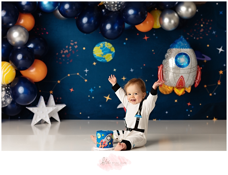 Calgary space themed cake smash astronaut boy hands in air