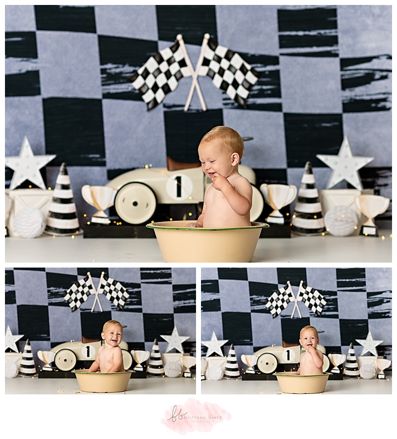 One year old boy splashing around during Fast One themed cake smash
