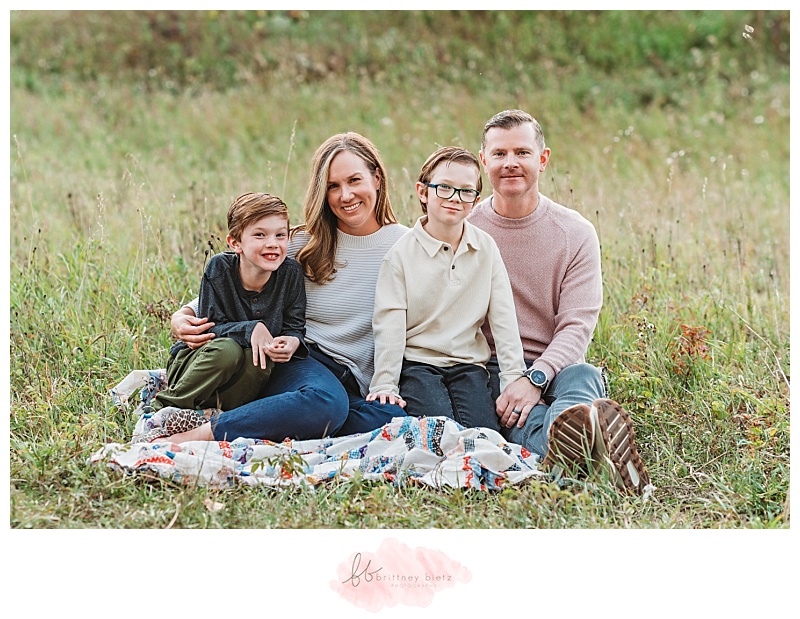 Family of four sitting down in a field in Calgary