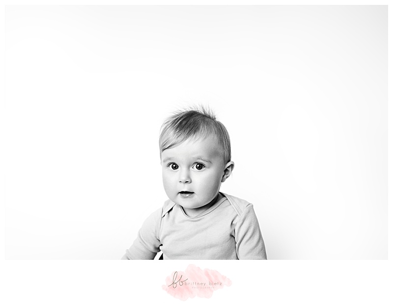 black and white portrait of a baby looking at camera intrigued