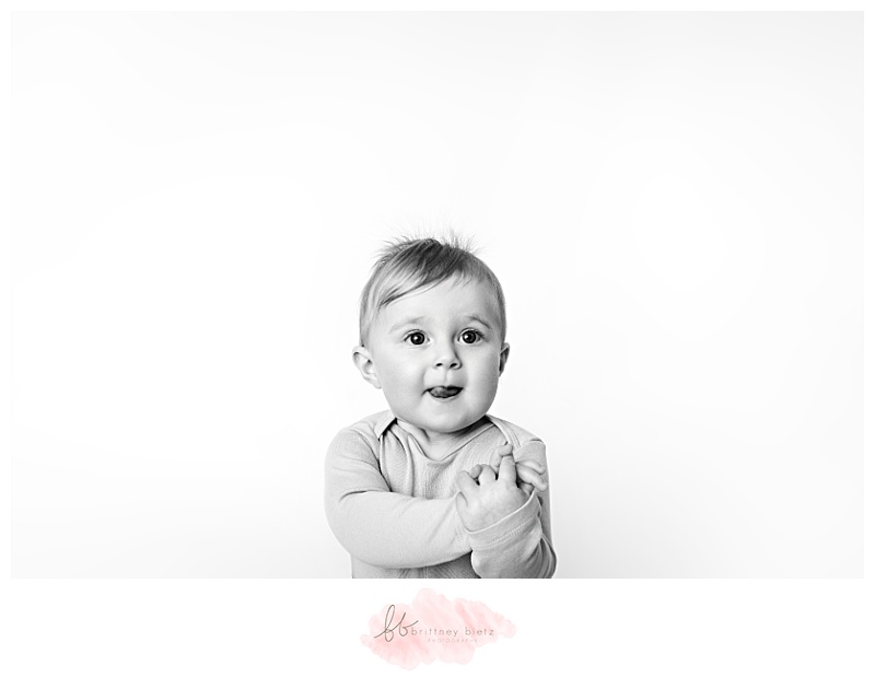 black and white portrait of a baby with tongue sticking out