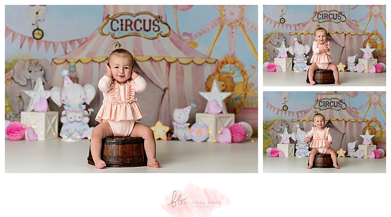 Baby girl sitting on bucket during her circus-themed cake smash in Calgary