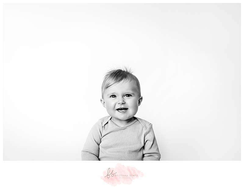 black and white portrait of a baby giving a toothy smile