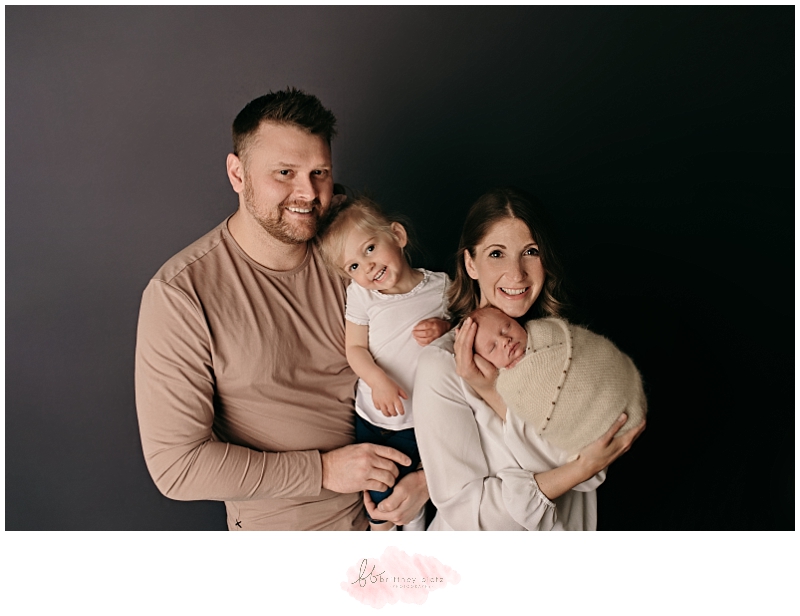 family of 4 on dark grey backdrop