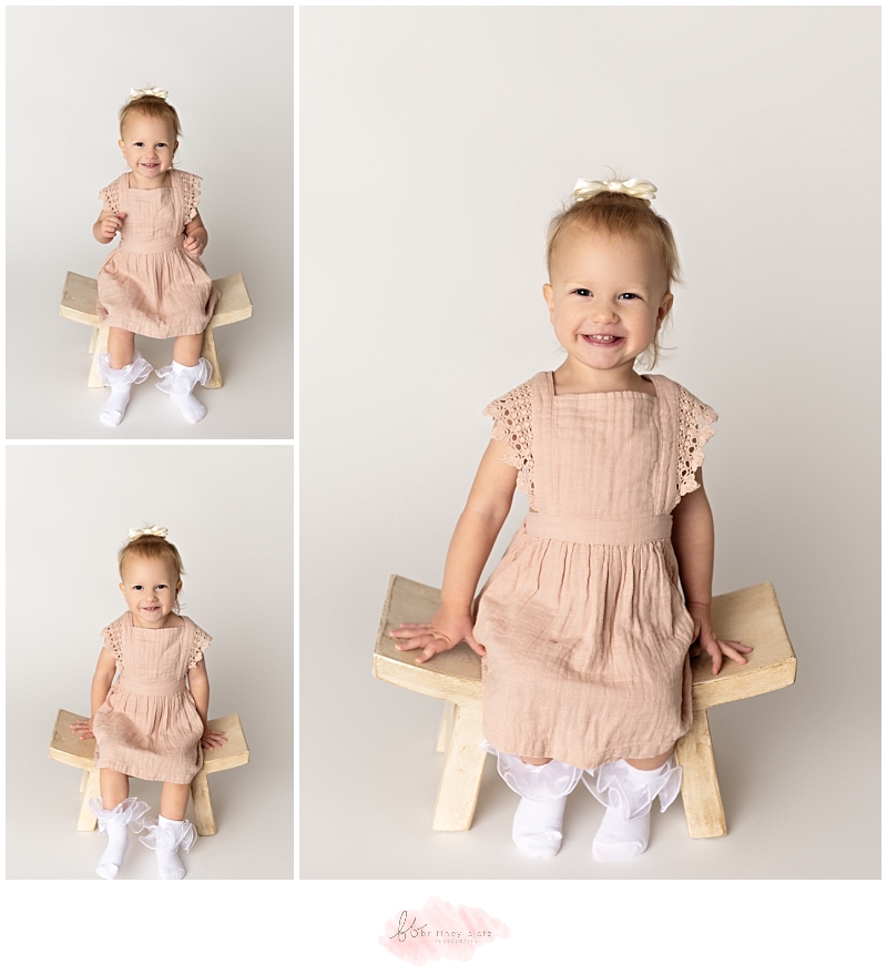 2-year old girl sitting on still smiling at camera