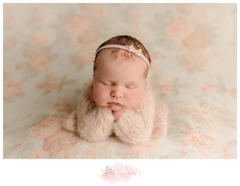 Cochrane newborn baby girl in froggy pose on floral fabric