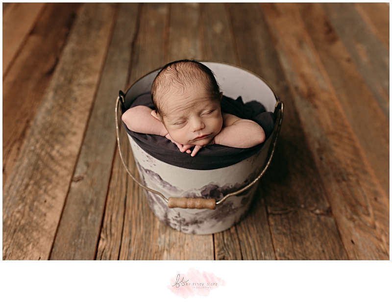 Sleeping baby boy in bucket with mountain decal